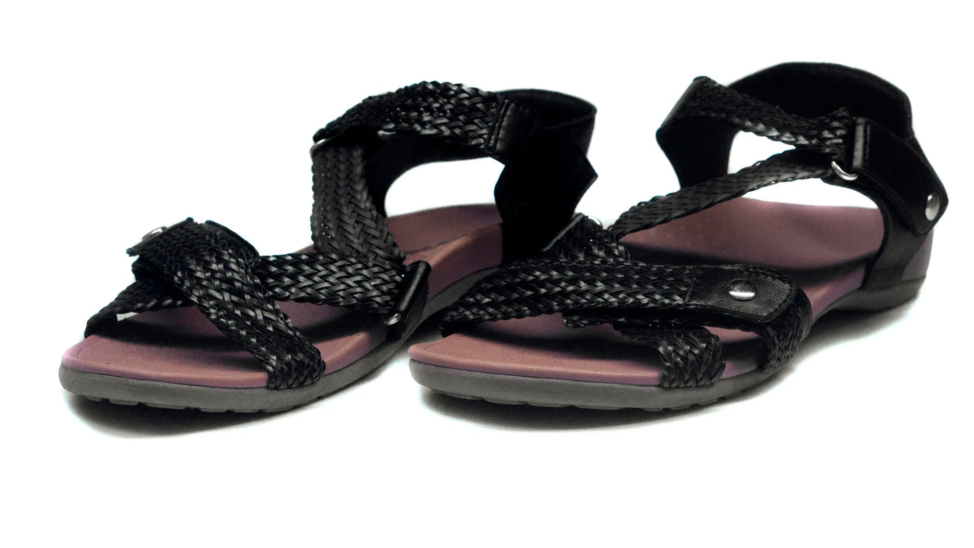 Black sandals with braided design on a white background