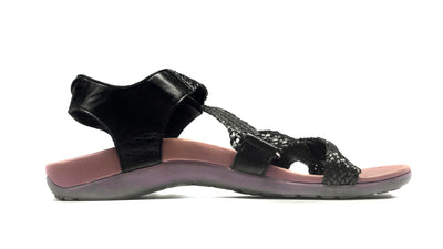 Black sandal with pink sole on a white background
