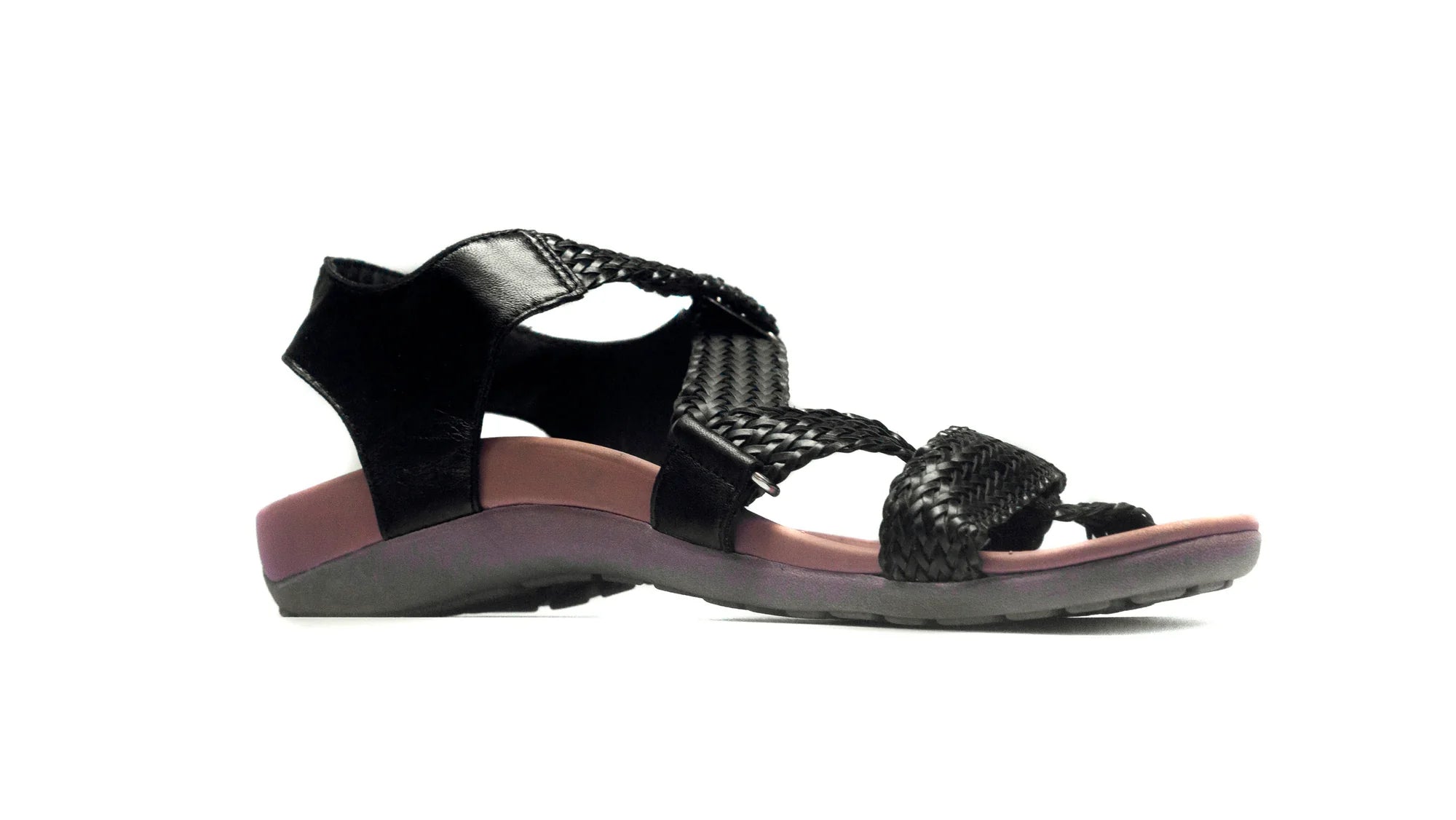 Black sandal with pink sole on a white background