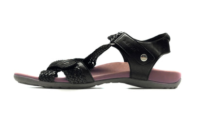 Black sandal with pink sole on a white background