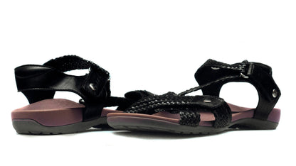 Black sandals with braided straps on a white background