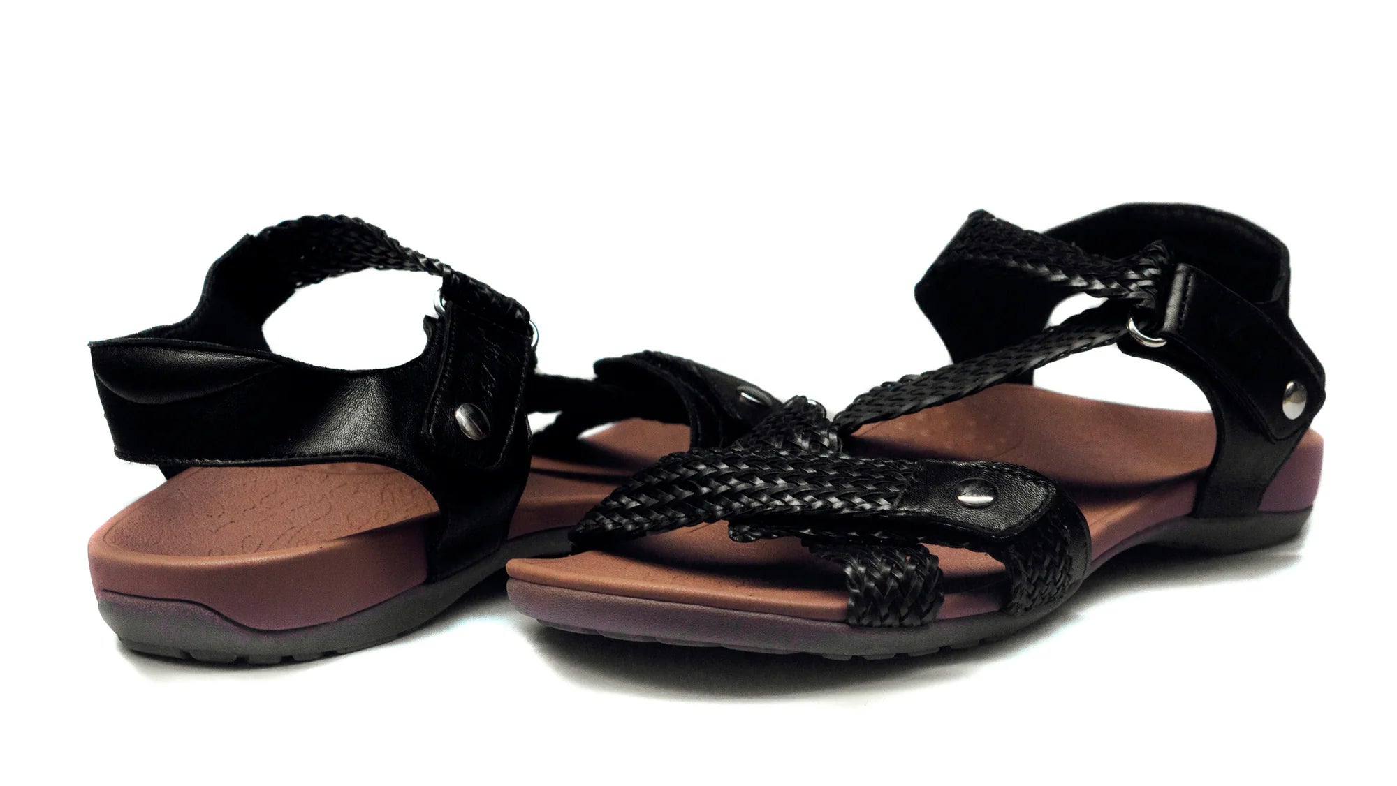Black sandals with braided design on a white background