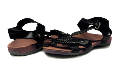 Black sandals with braided design on a white background