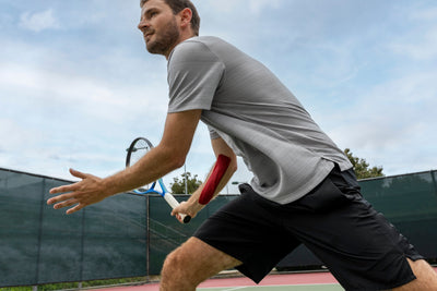 Tennis player in action wearing RockTape RHEON kinesiology tape